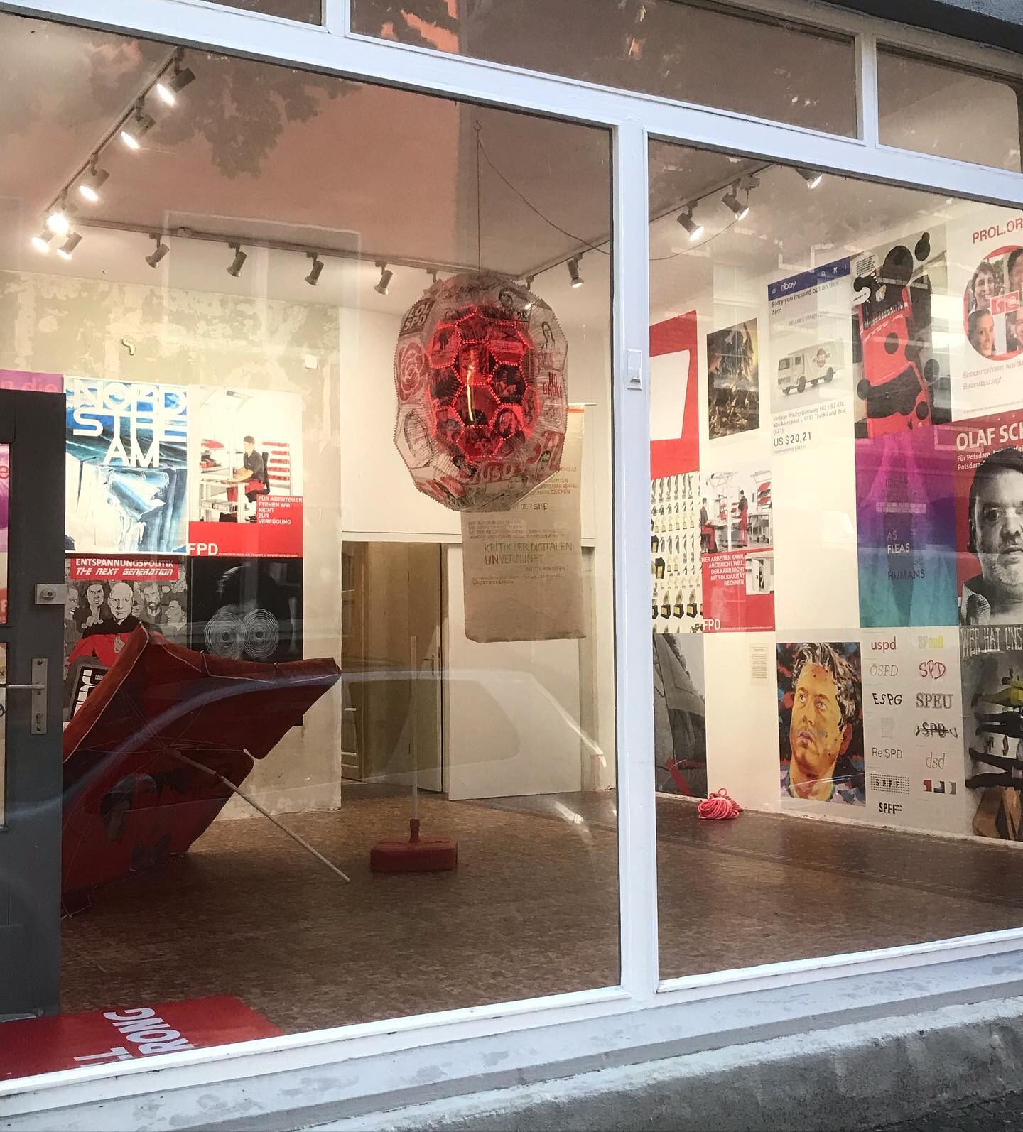 «Die Zukunft der SPD #2» — Schaufensteransicht mit Lichtobjekt und bemaltem Sonnenschirm