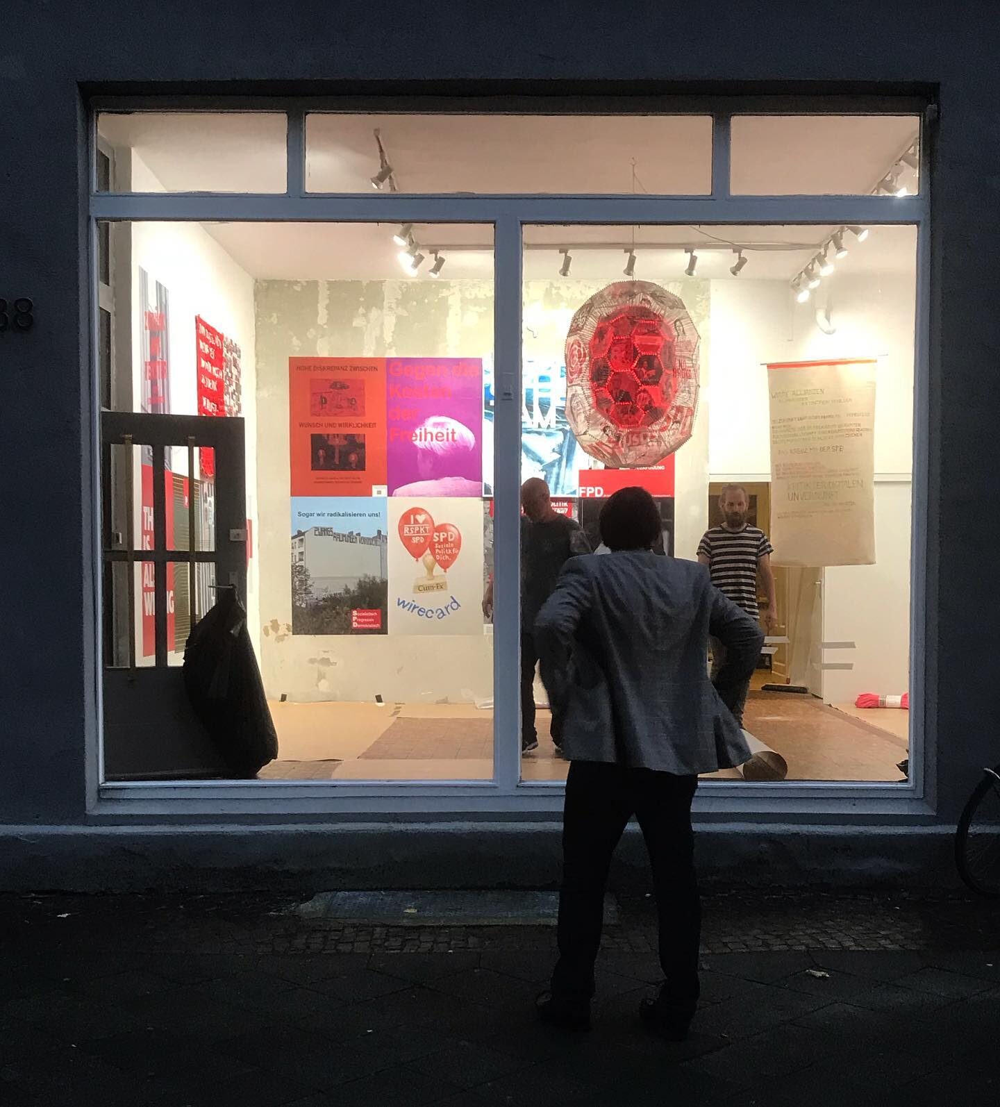 «Die Zukunft der SPD #2» — Schaufensteransicht bei Nacht mit Besuchern