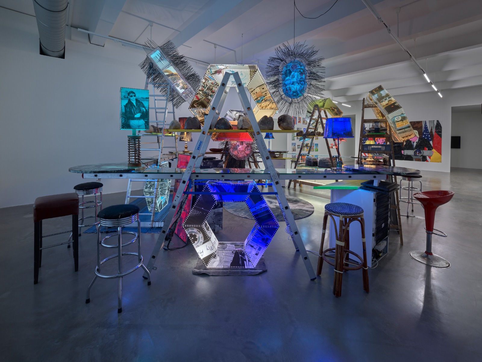 Bar-Installation mit spiegelnden Hexagon-Leuchtkörpern und Portraitlampen